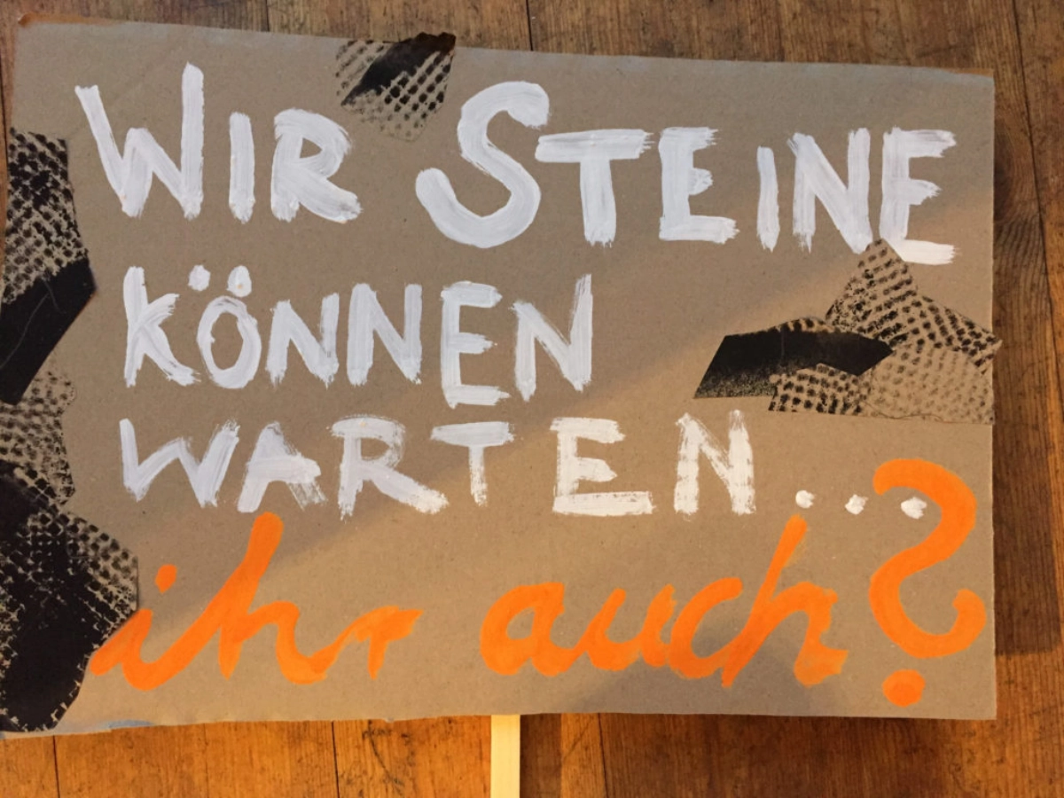 Ein Demoschild mit der Aufschrift: "Wir Steine können warten ... Ihr auch?"