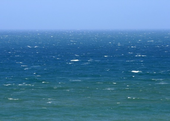Das Bild zeigt ein Meer mit Wellen und leichten Schaumkronen